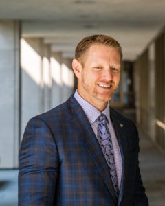 A picture of me in a sports jacket with a purple tie and shirt.